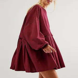 Detailed side view of a burgundy fake two-piece sweatshirt dress with pleated skirt