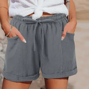 Dettaglio ravvicinato di pantaloncini grigi a vita alta in lino con coulisse e tasche.
