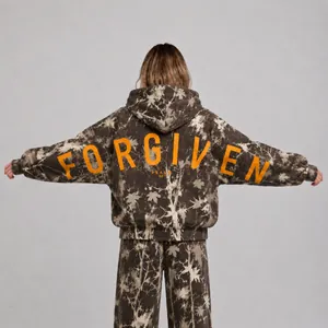 Back view of a camouflage oversized hoodie with orange Forgiven print and religious text