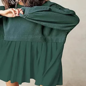 Detail shot of green pleated sweatshirt dress showing fabric texture