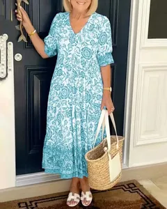 Elegant blue and white floral V-neck bohemian maxi dress styled with a straw tote bag