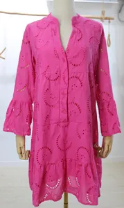 Détail d'une robe rose fuchsia avec dentelle brodée, col en V et manches évasées