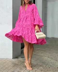 Vue détaillée d'une robe courte rose à col en V avec broderie anglaise et volants étagés.