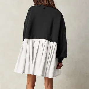 Back view of a minimalist black sweatshirt dress with a white pleated hem detail