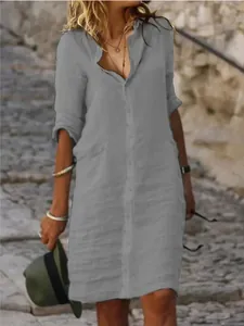 Close-up of a casual gray linen shirt dress with button detailing and lapel collar
