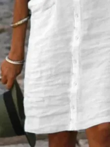Dettaglio ravvicinato di un abito a camicia bianco in cotone e lino con bottoni