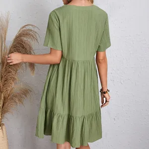 Back view of a sage green tiered summer dress featuring unique textured fabric detail