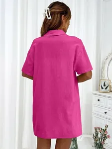 Vista trasera de una camisa de manga corta magenta con un diseño de corte holgado