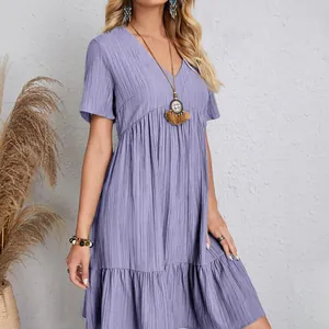 Detail of lavender crinkle fabric on a loose short-sleeved tiered V-neck casual dress