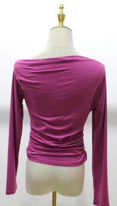 Back view of magenta long sleeve asymmetrical crop top on a female mannequin
