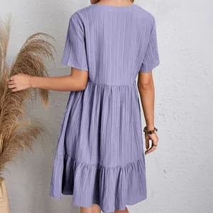 Rear view of a purple short-sleeved tiered flowy casual dress featuring textured gauze fabric