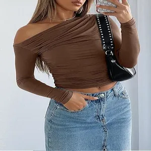 Detail view of the brown asymmetric one-shoulder ruched crop top showing slim fit