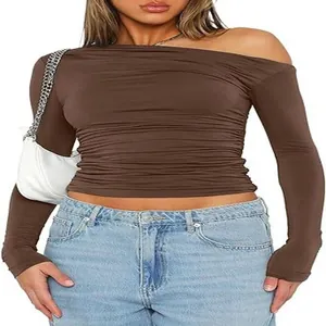 Detailed view of a brown asymmetric ruched long sleeve crop top on a female model