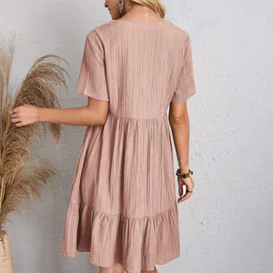 Back view of a casual pink short-sleeved babydoll dress with tiered skirt detail.