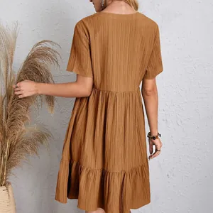 Detailed back view of a brown textured short-sleeve tiered mini dress with ruffle hem detail