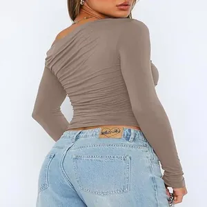 Detailed close-up of brown ruched long sleeve one shoulder crop top showing texture
