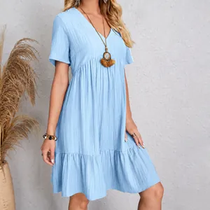Detailed view of light blue v-neck summer dress with crinkle fabric and tiered hem