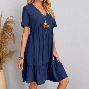Detailed view of a navy blue short-sleeved tiered dress with crinkled texture and V-neckline