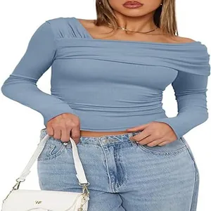 Détail du haut bleu à une épaule et manches longues pour femme avec buste froncé et coupe slim.