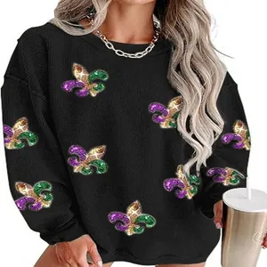 Close-up detail of women's black sweatshirt with glitter Mardi Gras Fleur-de-lis patterns