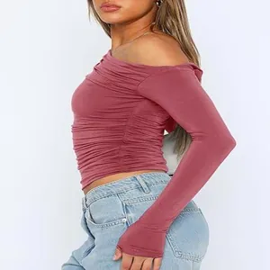 Side view detail of a ruched off-shoulder long sleeve crop top in mauve.