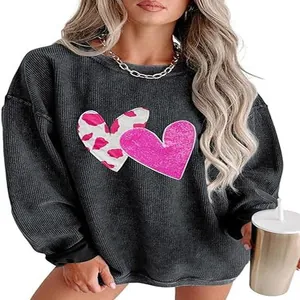 Detail view of women's grey waffle knit sweatshirt with cow print and pink hearts