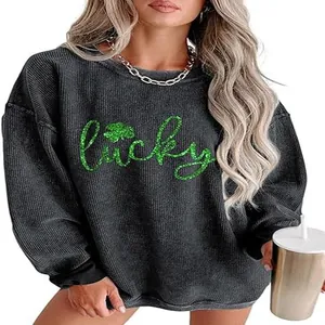 Close-up detail of women's grey waffle knit sweatshirt with green glitter Lucky print