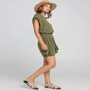 Vista laterale di una donna in tutina casual in lino verde oliva con coulisse regolabile