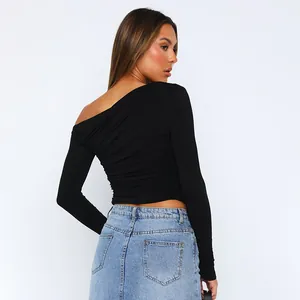 Detailansicht der Rückseite eines schwarzen asymmetrischen langärmligen Crop-Tops