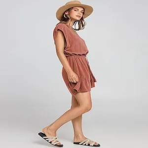Vista laterale completa di una donna con una tutina casual in cotone e lino terracotta