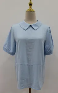 Detailed view of light blue cotton short-sleeve shirt featuring a Peter Pan collar