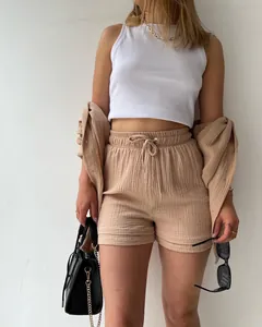Detail showing the crinkle fabric texture of a khaki two-piece shirt and shorts set.