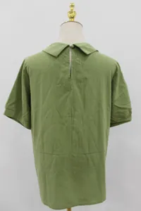 Detail view of the back of a women's loose green cotton shirt with Peter Pan collar.