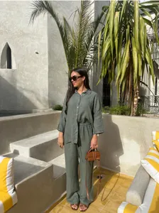 Femme élégante portant un ensemble chemise et pantalon en lin vert foncé dans un hôtel