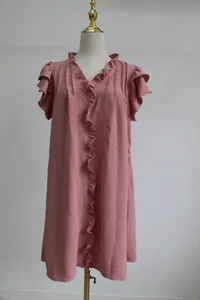 Detail view of a loose pink V-neck dress with elegant ruffle trim on the sleeves.