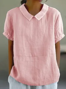 Close-up detail of the pink cotton blouse's collar and front texture on a model.