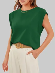 Detail of women's dark green cap sleeve top paired with white trousers and belt