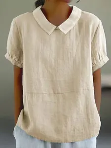 Close-up of women's beige loose linen-cotton shirt with white Peter Pan collar