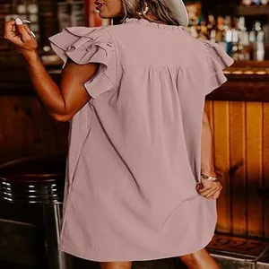 Relaxed fit mauve mini dress with ruffle sleeves shown from the back in a casual bar setting.