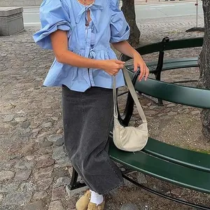 Sweet light blue puff sleeve blouse with bow tie details in a lifestyle street setting.