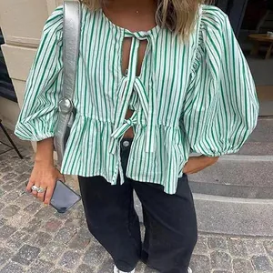 Close-up detail of green and white striped tie-front puff sleeve blouse with round neck