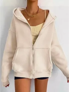 Detalle de una sudadera con capucha beige de gran tamaño para mujer con cremallera.