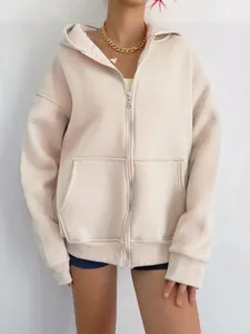 Primer plano de una sudadera con capucha y cremallera extragrande en color crema.