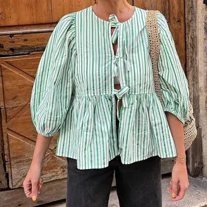 Detail of green and white striped blouse with tie-front bows and puff sleeves