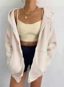 Detalle de chaqueta con capucha beige de gran tamaño para mujer con cremallera estilo casual