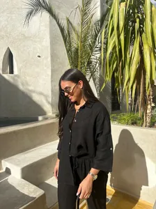 Femme chic portant un ensemble décontracté en lin noir à l'extérieur sous le soleil