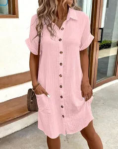 Detailed view of pink V-neck cotton linen shirt dress featuring wooden buttons and pockets
