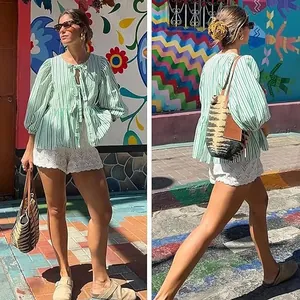 Women's sweet casual green striped blouse with puff sleeves and tie neck in summer scene.