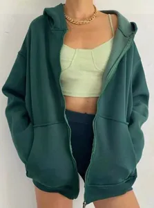 Primer plano de una sudadera con capucha oversize verde oscuro para mujer con bolsillos