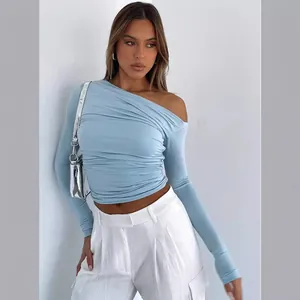 Sexy light blue asymmetric off-the-shoulder long sleeve ruched crop top on a model